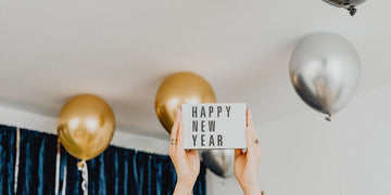 Happy New Year lightbox sign with balloons representing fresh starts and New Year cleaning resolutions.